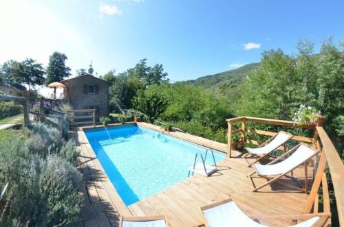 una piscina en una terraza de madera con sillas alrededor en Ferienhaus mit Privatpool für 6 Personen ca 95 qm in Castelvecchio, Toskana Provinz Pistoia en Aramo