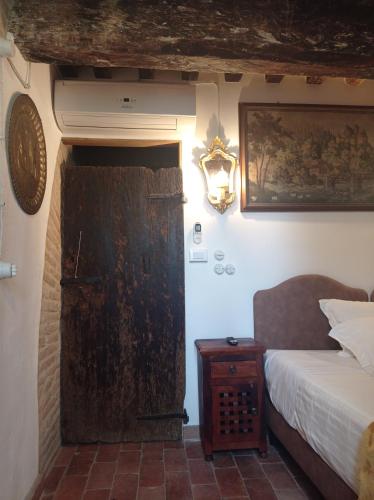 a bedroom with a bed and a wooden door at Tenuta Torre Diana in Mordano