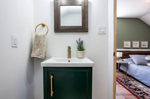 a bathroom with a green sink and a mirror at Cottontail Cabin with Hot Tub and wood fired Sauna in Merrickville