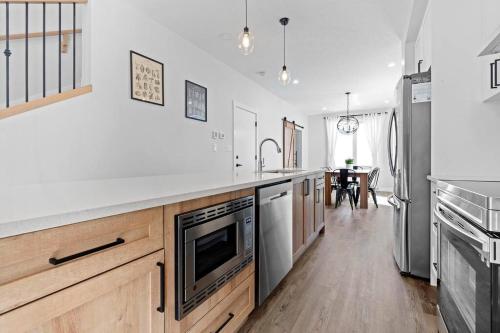 a kitchen with a large white counter top with a sink at Modern Luxury Home - King Bed•Arcade•WEM•A/C in Edmonton