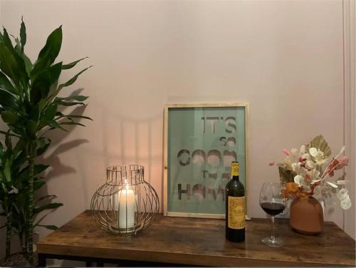 - une table avec une bouteille de vin et un verre dans l'établissement Cozy Apt à Bordeaux centre, idéal pour vos séjours, à Bordeaux