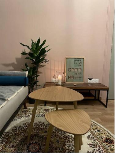 een woonkamer met 2 tafels en een bank bij Cozy Apt à Bordeaux centre, idéal pour vos séjours in Bordeaux