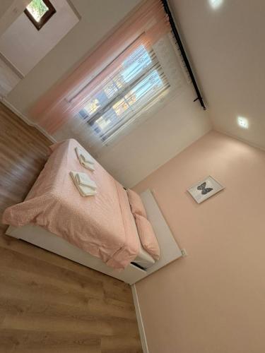 um quarto com um cobertor rosa e uma janela em STATION AND AiRPORT ROOM'S em Pisa