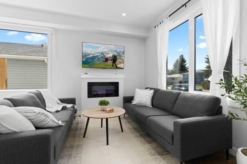 a living room with two couches and a table at Modern Luxury Home - King Bed•Arcade•WEM•A/C in Edmonton