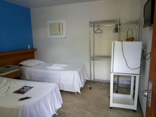 um quarto com 2 camas e um frigorífico em Pousada In Paradiso em Santa Cruz
