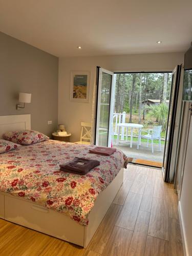 sypialnia z łóżkiem i przesuwnymi szklanymi drzwiami w obiekcie Villa MA&VA w mieście Lacanau-Océan