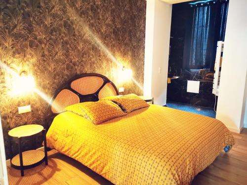 1 dormitorio con 1 cama con edredón amarillo en Le moderne 100 mètres de la gare parking gratuit, en Douai