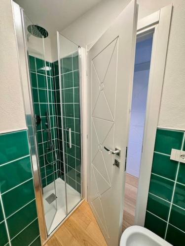a bathroom with a shower and a toilet with green tiles at One & Only in Cala Bitta