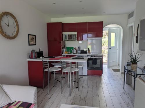 eine Küche mit roten Schränken und einem Tisch mit Stühlen in der Unterkunft Joli F2 Saint Endreol HAMEAU PALAYSON Var in La Motte