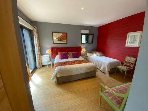 CarcèsにあるVilla Chamarelの赤い壁のベッドルーム1室(ベッド2台付)
