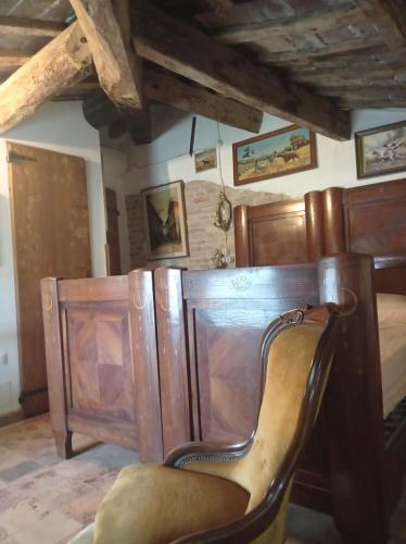 a chair sitting in a room with a bed at Tenuta Torre Diana in Mordano