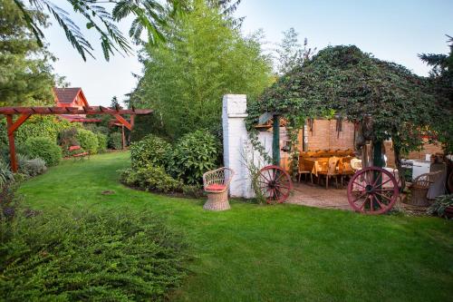 a garden with a table and a horse drawn carriage at Green Park Villa in Eger