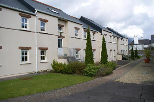 a row of white houses on a street at Sheraton Lodge Apartments t12e309 in Cork