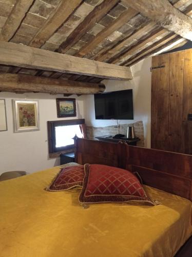 a bedroom with a bed with a wooden headboard and a television at Tenuta Torre Diana in Mordano