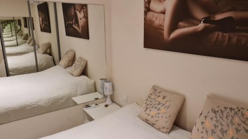 a small bedroom with a bed and a mirror at Appartement Naturiste de Standing 3* Heliopolis AB in Cap d'Agde