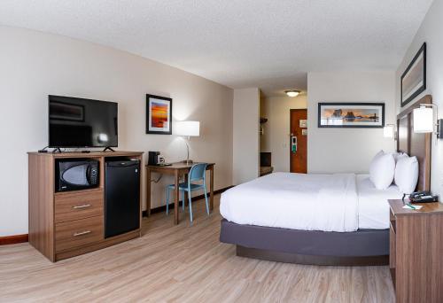 ein Hotelzimmer mit einem Bett und einem Flachbild-TV in der Unterkunft Quality Inn Milan-Sandusky in Milan