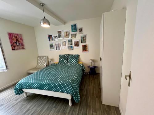 une chambre avec un lit et des tableaux au mur dans l'établissement Le Duplex d'Austin Power, à Orléans