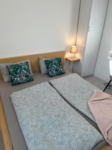 a bed with two pillows on it in a room at Marton Apartman in Balatonszemes