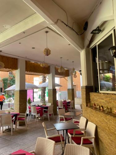 un restaurante con mesas y sillas en un patio en Riad Palmeraie en Marrakech