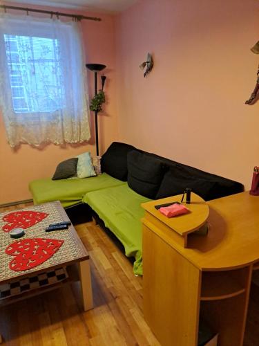 a living room with a green couch and a table at Marie in Ludgeřovice