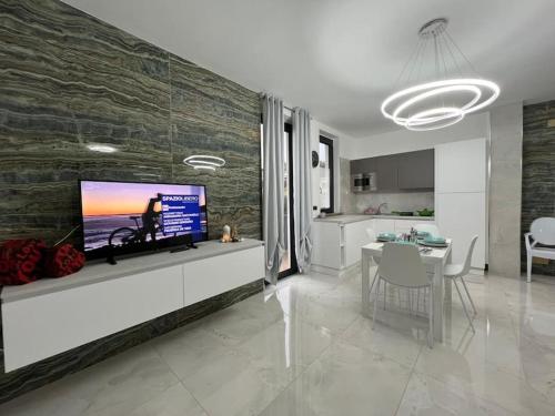 eine Küche und ein Wohnzimmer mit einem TV an der Wand in der Unterkunft RESIDENCE MARCO POLO in Montesilvano