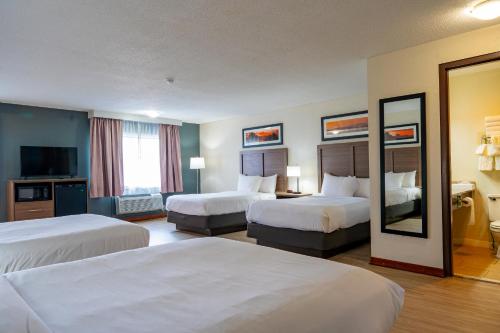 a hotel room with two beds and a mirror at Quality Inn Milan-Sandusky in Milan