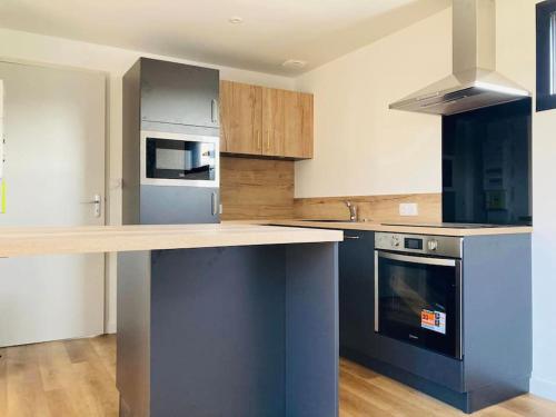 - une cuisine avec un comptoir et une cuisinière dans l'établissement LA PARENTHESE DU GUILLEC, à Plougoulm