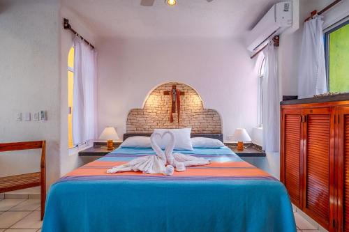a bedroom with a bed with towels on it at Del Sol Beachfront in Akumal