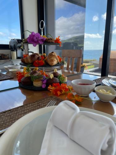stół z talerzem jedzenia na stole w obiekcie Xhale Azores w mieście Angra do Heroísmo
