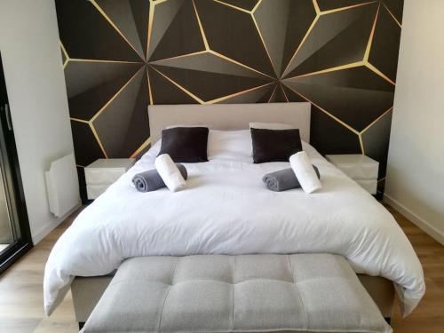 une chambre avec un grand lit blanc avec des oreillers dans l'établissement LA PARENTHESE DU GUILLEC, à Plougoulm