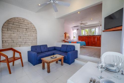 a living room with a blue couch and a table at Del Sol Beachfront in Akumal