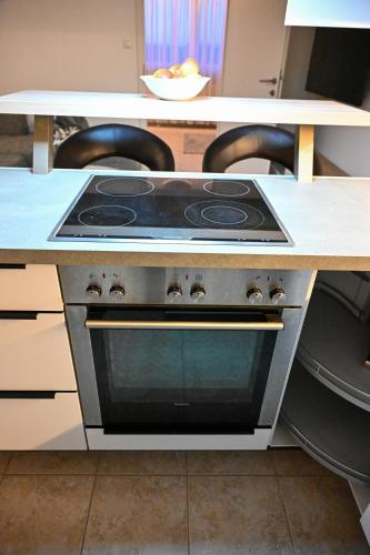 a stove top oven sitting under a counter in a kitchen at Losensteinleiten Naturglanz Apartment in Losensteinleithen