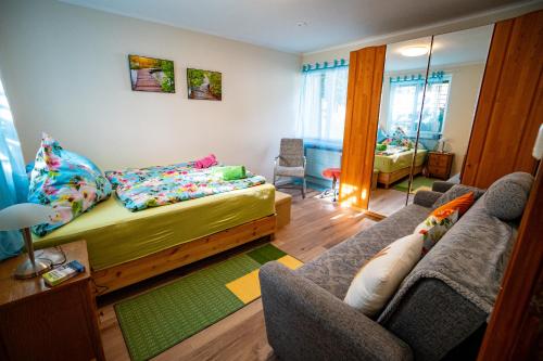 - une chambre avec un lit et un canapé dans l'établissement Gemütliches Haus mit Terasse und Feuerstelle, à Lengnau