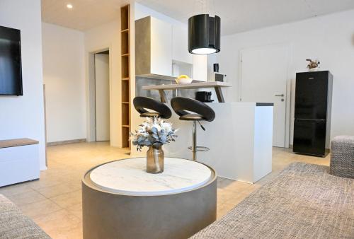 a living room with a table with a vase of flowers at Losensteinleiten Naturglanz Apartment in Losensteinleithen