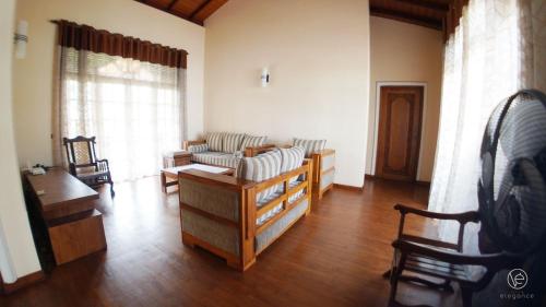 uma sala de estar com um sofá, uma mesa e cadeiras em Villa Elegance 112 em Sri Jayewardenepur- Kotte
