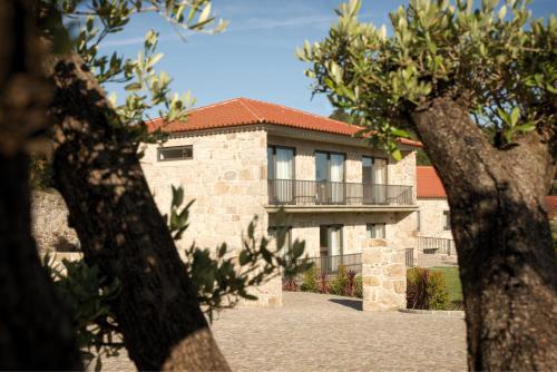 una casa in pietra con balcone di fronte di Paços do Douro, Chambre privée avec piscine a Romariz