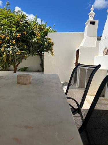a table and chairs on a patio with a tree at A casa dos Avós in Campo Maior