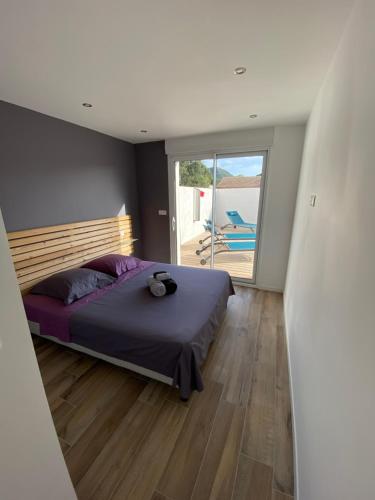 une chambre avec un grand lit et un balcon dans l'établissement Maison neuve Porto Vecchio, à Porto-Vecchio
