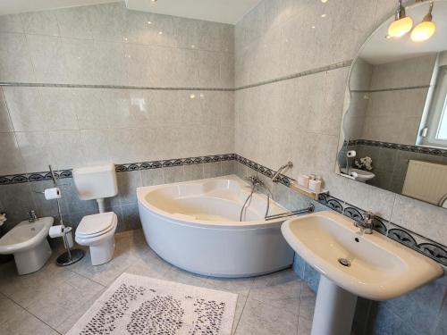 e bagno con vasca, servizi igienici e lavandino. di Apartments Kricin 14 a Baška