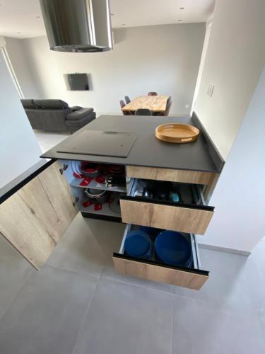 une cuisine avec un îlot et une table dans l'établissement Maison neuve Porto Vecchio, à Porto-Vecchio