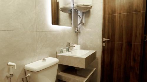 a bathroom with a sink and a toilet and a mirror at Masaya Al Deyar Apartments in Amman