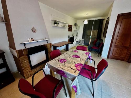 sala de estar con mesa y sillas rojas en Casa Rural Familiar , Castilleja del Campo , Sevilla, en Sevilla