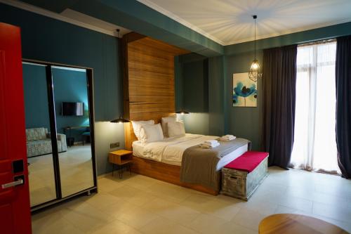 a bedroom with a bed in a room with green walls at Boulevardside in Batumi