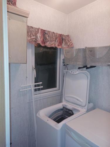 Skurup的住宿－Villavagn på landet östra Skurup，小型客房设有窗户,配有洗衣机。