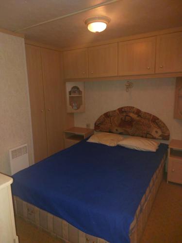 Skurup的住宿－Villavagn på landet östra Skurup，一间卧室配有一张带蓝色毯子的大床