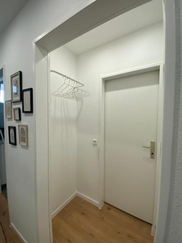 een hal met een witte deur en een witte muur bij Apartment Wesseling Zentrum in Wesseling
