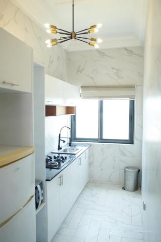 uma cozinha com armários brancos e um tecto em Le VÏU STUDIO 3 em Cotonou