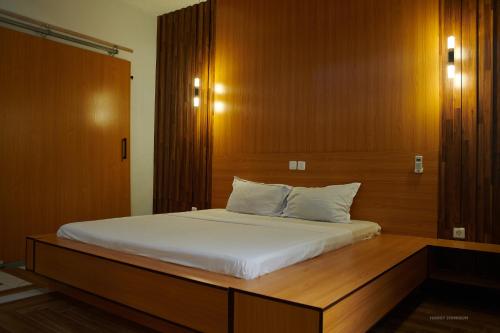 um quarto com uma cama grande e uma cabeceira em madeira em Le VÏU STUDIO 3 em Cotonou