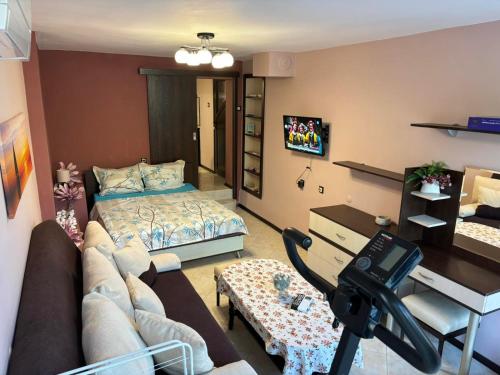 - un salon avec un lit et un bureau dans l'établissement Партерно Студио, à Ahtopol