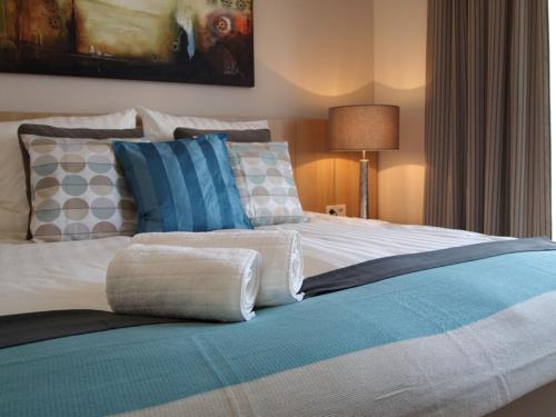 a large bed with pillows on it in a bedroom at Wohnung 10 Haus Oldenburg in Wangerooge
